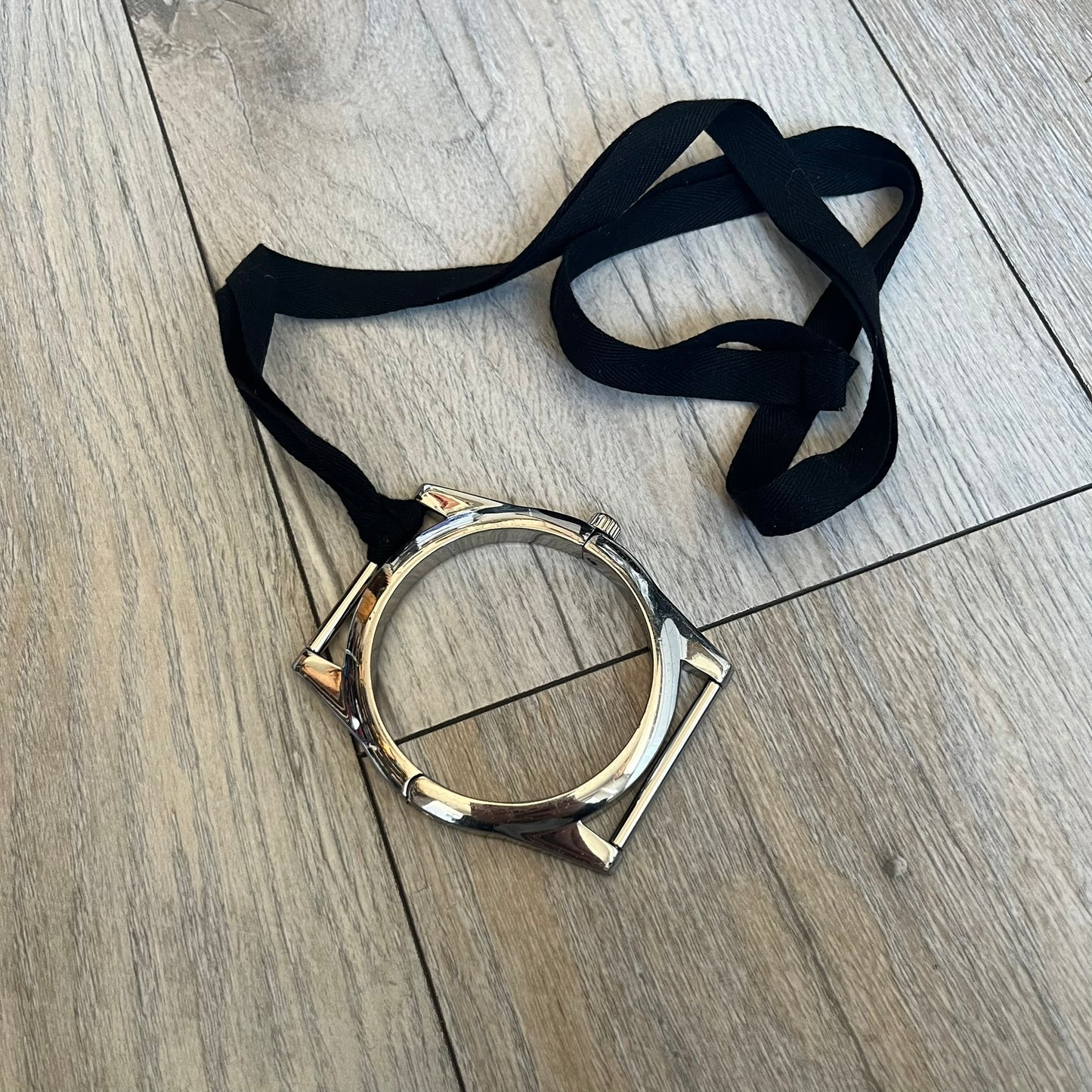 Maison Margiela x H&amp;M AW09 Enlarged Watch Frame Bracelet is a stainless steel bracelet from the 2012 collaboration between Maison Margiela and H&amp;M, based on an original Autumn/Winter 2009 design. The piece is shaped like an oversized watch case but functions as a bracelet, featuring a side clasp opening mechanism. It includes engraved tonal branding on the interior and can also be worn as a pendant. Made in Italy, it comes with the original box, dustbag, and tags.