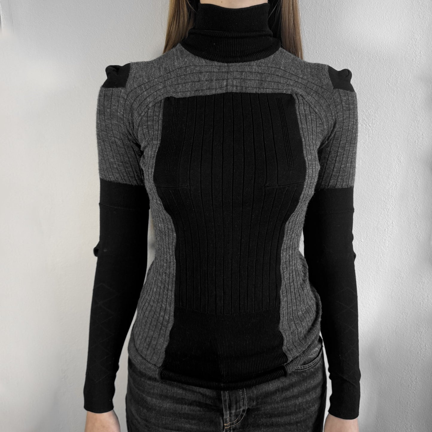 Maison Margiela x H&amp;M AW12 wool sweater in gray and black, designed with stretch fabric for a snug, comfortable fit. Features sock-inspired panels with heel details on the shoulders and elbows, a turtleneck, and long sleeves. A standout piece from the 2012 collaboration, inspired by Margiela’s Fall 1989 collection.