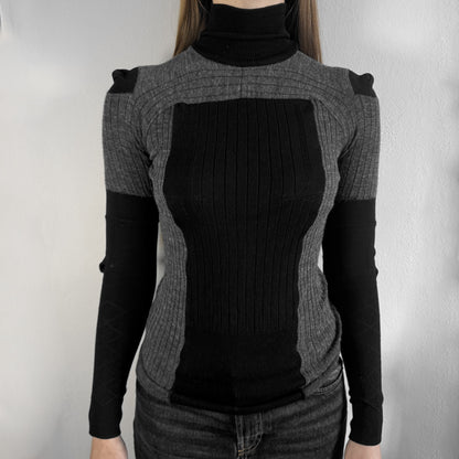 Maison Margiela x H&amp;M AW12 wool sweater in gray and black, designed with stretch fabric for a snug, comfortable fit. Features sock-inspired panels with heel details on the shoulders and elbows, a turtleneck, and long sleeves. A standout piece from the 2012 collaboration, inspired by Margiela’s Fall 1989 collection.