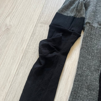 Maison Margiela x H&amp;M AW12 wool sweater in gray and black, designed with stretch fabric for a snug, comfortable fit. Features sock-inspired panels with heel details on the shoulders and elbows, a turtleneck, and long sleeves. A standout piece from the 2012 collaboration, inspired by Margiela’s Fall 1989 collection.