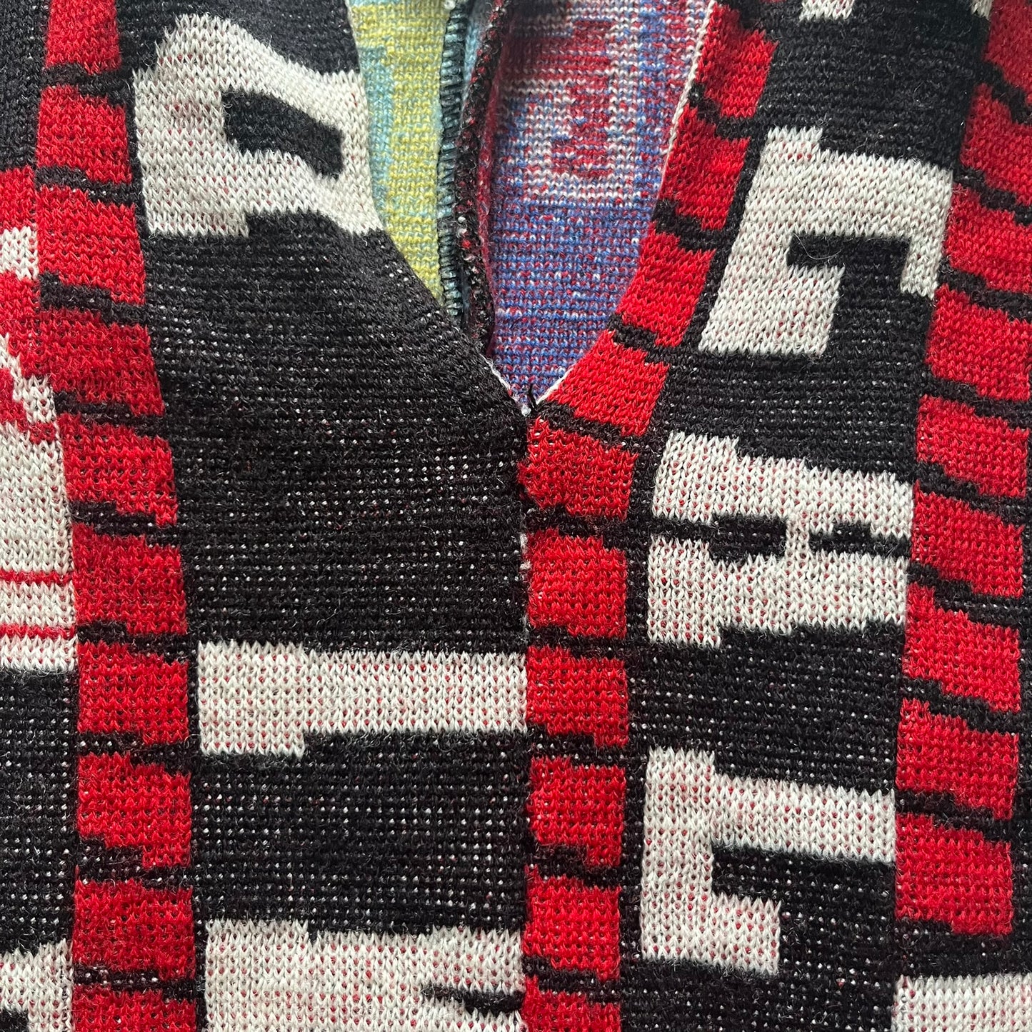 Close-up of a patterned fabric with red, black, and white colors.