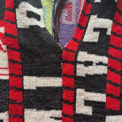 Close-up of a patterned fabric with red, black, and white colors.