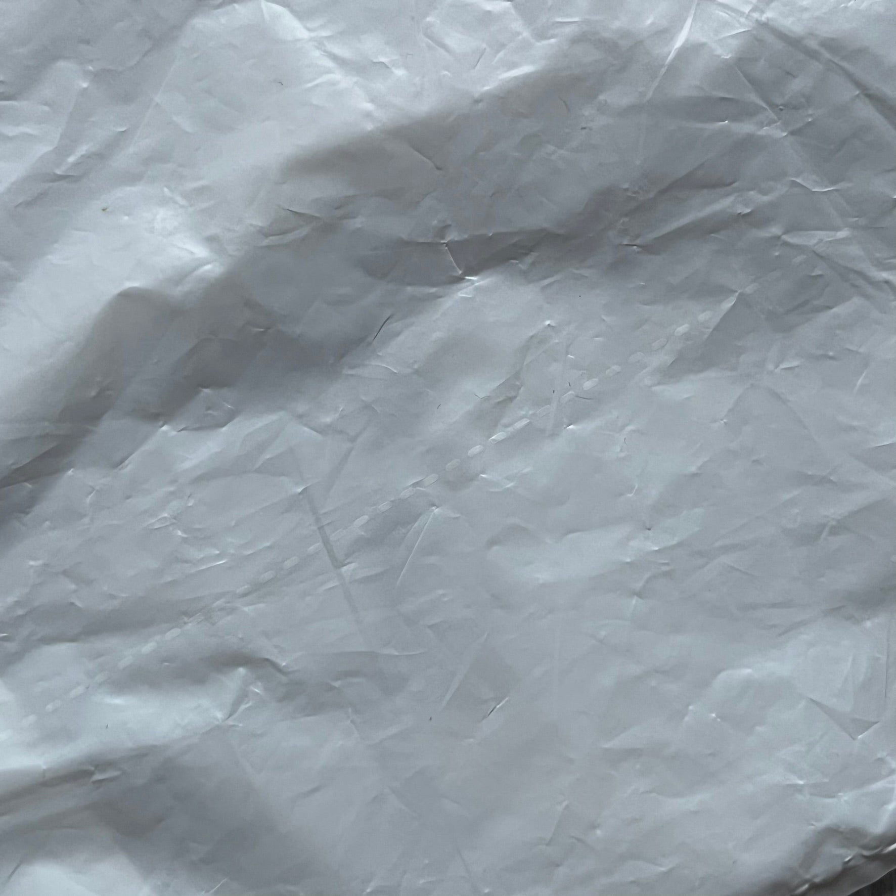 Clear/white plastic bag from the Maison Margiela x H&amp;M collaboration, designed with a cut-off bottom that allows it to be worn as a top or tank. Features big Maison Margiela x H&amp;M logos printed on the front, visible through the semi-transparent material.