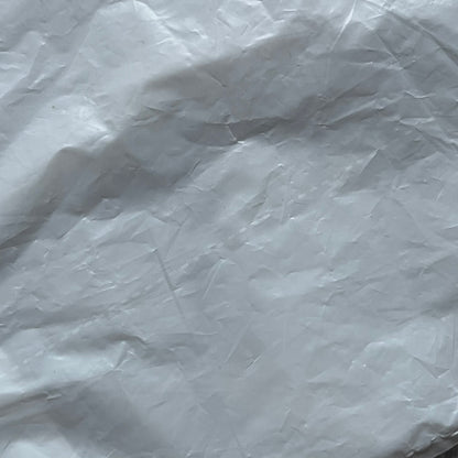 Clear/white plastic bag from the Maison Margiela x H&amp;M collaboration, designed with a cut-off bottom that allows it to be worn as a top or tank. Features big Maison Margiela x H&amp;M logos printed on the front, visible through the semi-transparent material.