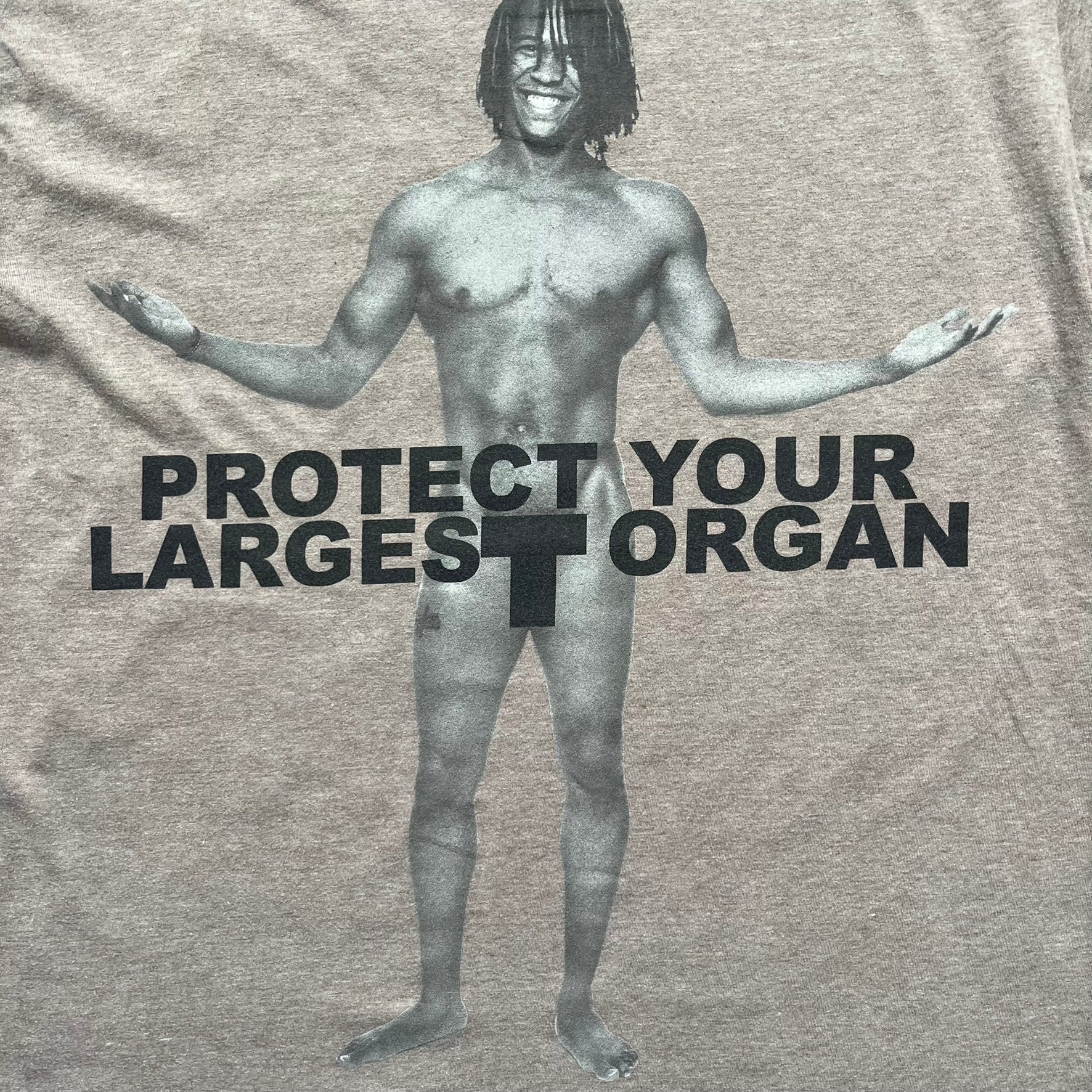 Marc Jacobs 2010s “Protect Your Largest Organ” Chico Clark T-shirt is a light brown awareness campaign tee created to support skin cancer prevention initiatives. The front features an artistic illustration of Chico Clark with accompanying “Protect Your Largest Organ” text. The sleeves include printed details referencing the collaboration and support for NYU School of Medicine. The back displays a large “Thank You” message with credits to contributors involved in the campaign.