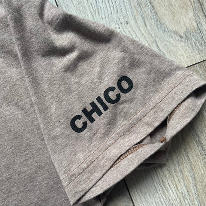 Marc Jacobs 2010s “Protect Your Largest Organ” Chico Clark T-shirt is a light brown awareness campaign tee created to support skin cancer prevention initiatives. The front features an artistic illustration of Chico Clark with accompanying “Protect Your Largest Organ” text. The sleeves include printed details referencing the collaboration and support for NYU School of Medicine. The back displays a large “Thank You” message with credits to contributors involved in the campaign.