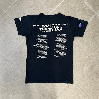 Marc Jacobs 2010s “Protect The Skin You’re In” Heidi Klum T-shirt is a black campaign tee created for skin cancer awareness. The front features an illustrative image of Heidi Klum with “Protect The Skin You’re In” text integrated into the design. The sleeves include "Heidi” and support for NYU Medical Center Cancer Institute. The back displays a large “Thank You” message listing contributors to the campaign.