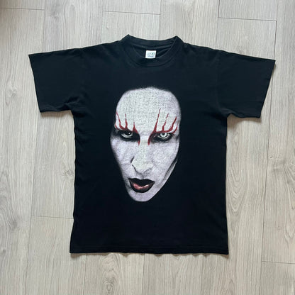Marilyn Manson Holy Wood Face Tee from 2000, made on a black BG blank. Features a large front graphic of Manson’s face with signature white makeup, red accents, and eye contact. The back includes red Marilyn Manson text with a small 2000 Giant license, great piece from the Holy Wood era.