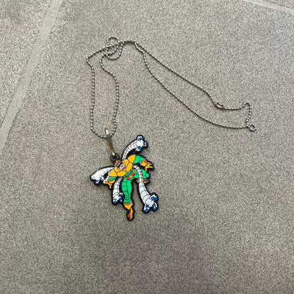 Marvel 1995 Doctor Octopus Necklace features a 2D cartoon-style Doctor Octopus pendant with a colorful graphic on the front. The back of the pendant is black and includes 1995 Marvel licensing details. It has a metal loop at the top and comes with a basic steel chain.
