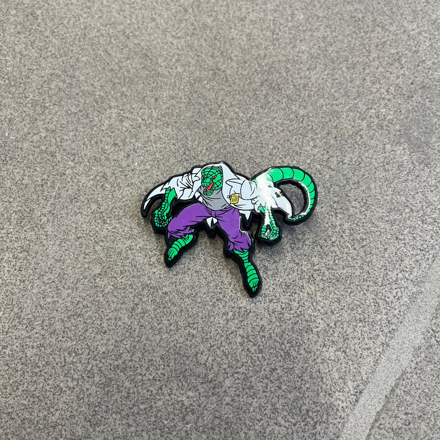 Marvel 1995 The Lizard Pin features a colorful 2D cartoon-style depiction of The Lizard (Dr. Curtis Connors). The back is black with official 1995 Marvel licensing and includes a standard pin fastening.
