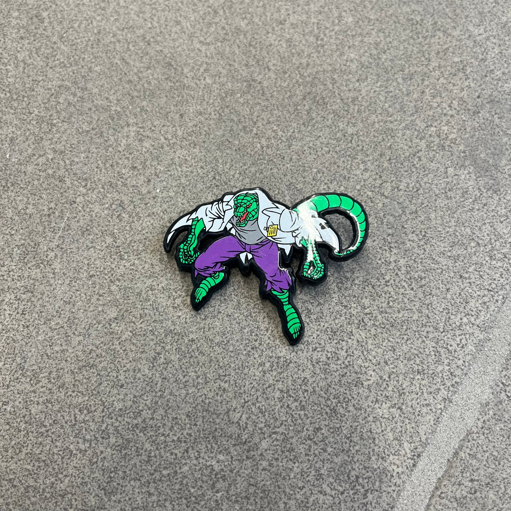 Marvel 1995 The Lizard Pin features a colorful 2D cartoon-style depiction of The Lizard (Dr. Curtis Connors). The back is black with official 1995 Marvel licensing and includes a standard pin fastening.
