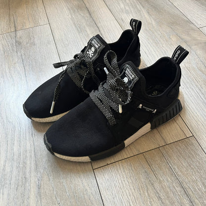 Mastermind x adidas NMD XR1 “Mastermind” Sneakers BA9726 are a 2016 collaboration between adidas and Mastermind Japan, the Japanese label founded by Masaaki Homma. The sneaker features a Core Black/Core Black/White colorway with a polyester mesh upper, rubber sole, and adidas Boost midsole. Mastermind’s signature skull and crossbones logo appears on the leather cage and tongue, while the pair includes black laces and follows the NMD XR1 silhouette released on September 20, 2016 under style code BA9726