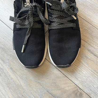 Mastermind x adidas NMD XR1 “Mastermind” Sneakers BA9726 are a 2016 collaboration between adidas and Mastermind Japan, the Japanese label founded by Masaaki Homma. The sneaker features a Core Black/Core Black/White colorway with a polyester mesh upper, rubber sole, and adidas Boost midsole. Mastermind’s signature skull and crossbones logo appears on the leather cage and tongue, while the pair includes black laces and follows the NMD XR1 silhouette released on September 20, 2016 under style code BA9726