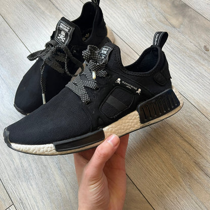 Mastermind x adidas NMD XR1 “Mastermind” Sneakers BA9726 are a 2016 collaboration between adidas and Mastermind Japan, the Japanese label founded by Masaaki Homma. The sneaker features a Core Black/Core Black/White colorway with a polyester mesh upper, rubber sole, and adidas Boost midsole. Mastermind’s signature skull and crossbones logo appears on the leather cage and tongue, while the pair includes black laces and follows the NMD XR1 silhouette released on September 20, 2016 under style code BA9726