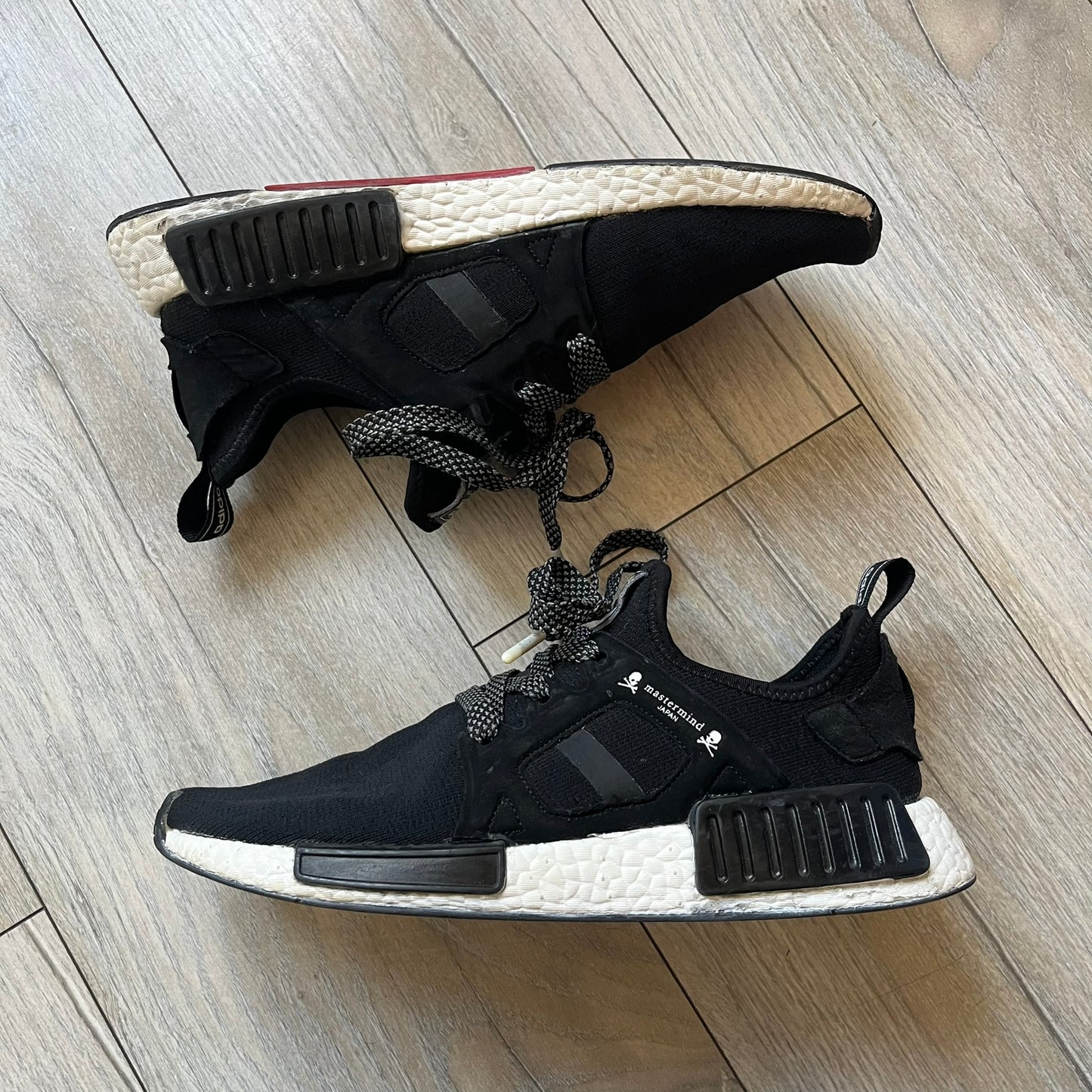 Mastermind x adidas NMD XR1 “Mastermind” Sneakers BA9726 are a 2016 collaboration between adidas and Mastermind Japan, the Japanese label founded by Masaaki Homma. The sneaker features a Core Black/Core Black/White colorway with a polyester mesh upper, rubber sole, and adidas Boost midsole. Mastermind’s signature skull and crossbones logo appears on the leather cage and tongue, while the pair includes black laces and follows the NMD XR1 silhouette released on September 20, 2016 under style code BA9726