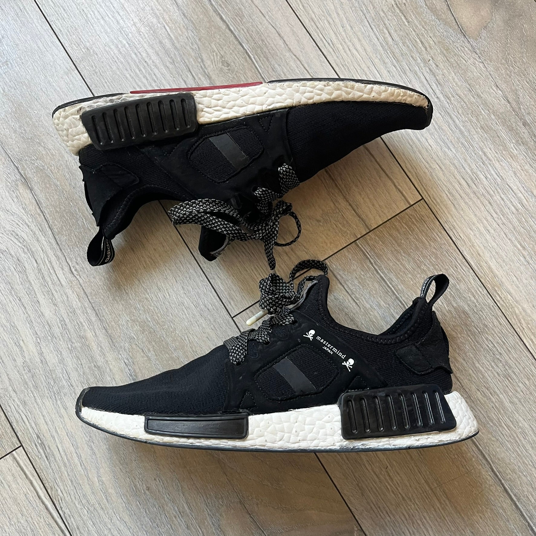 Mastermind x adidas NMD XR1 “Mastermind” Sneakers BA9726 are a 2016 collaboration between adidas and Mastermind Japan, the Japanese label founded by Masaaki Homma. The sneaker features a Core Black/Core Black/White colorway with a polyester mesh upper, rubber sole, and adidas Boost midsole. Mastermind’s signature skull and crossbones logo appears on the leather cage and tongue, while the pair includes black laces and follows the NMD XR1 silhouette released on September 20, 2016 under style code BA9726