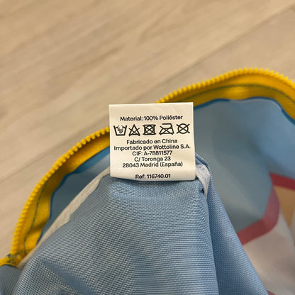 The McDonald’s Spain “Feel The Music” Backpack comes in a blue and yellow colorway with a vintage cassette graphic on the front. Constructed from lightweight non-woven synthetic fabric, it includes yellow straps and a zip-top closure. A collectible promotional item released by McDonald’s Spain.