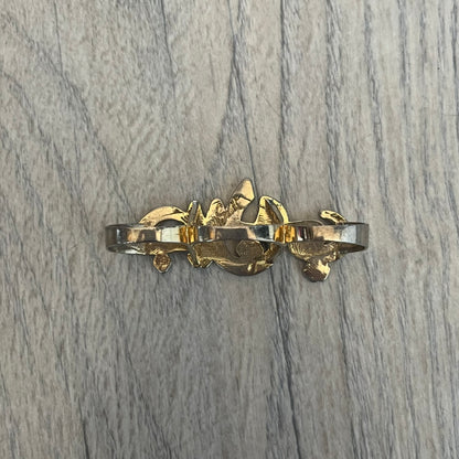 Melody Ehsani x Jeremy Scott 2013 Arabic Three Finger Ring is a gold-tone three-finger ring from the 2013 Fearless collection by Melody Ehsani and Jeremy Scott. The ring features the name “Jeremy” written in Arabic script across the three connected bands. Released in 2013, the piece originally retailed for $100.