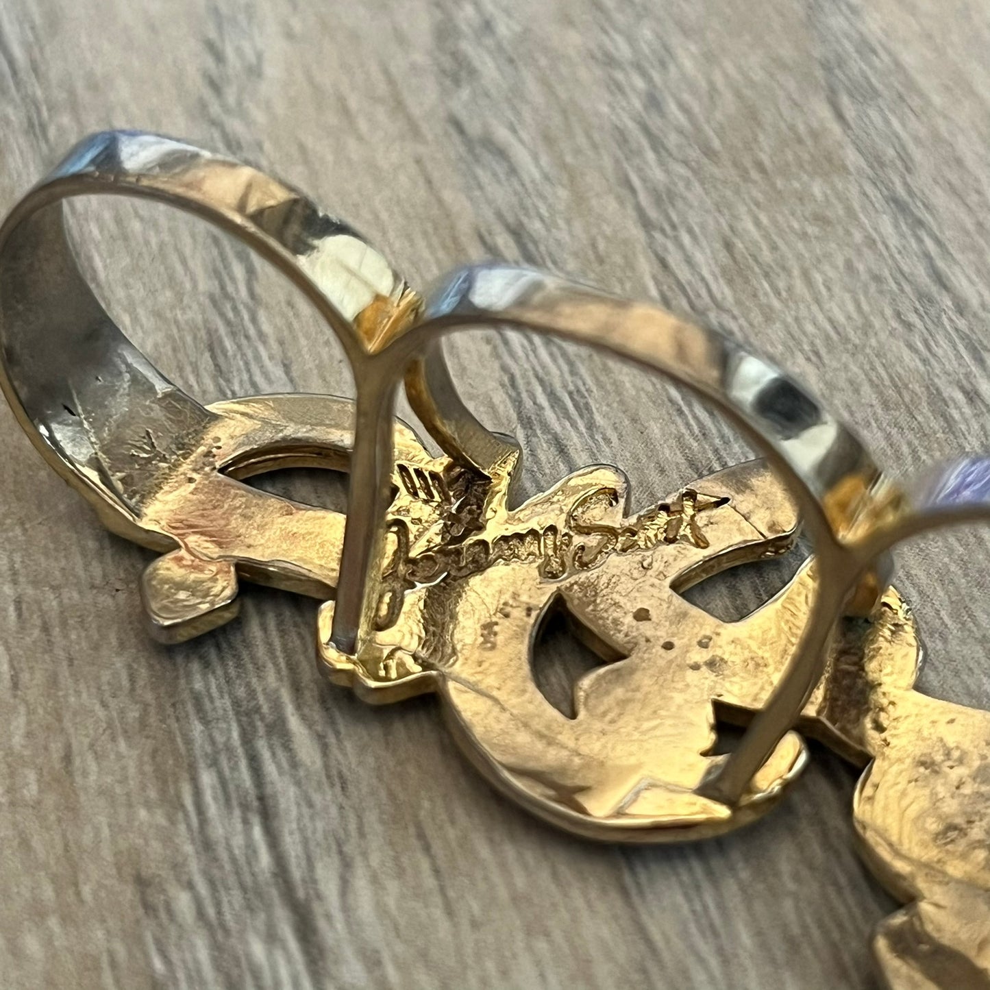 Melody Ehsani x Jeremy Scott 2013 Arabic Three Finger Ring is a gold-tone three-finger ring from the 2013 Fearless collection by Melody Ehsani and Jeremy Scott. The ring features the name “Jeremy” written in Arabic script across the three connected bands. Released in 2013, the piece originally retailed for $100.