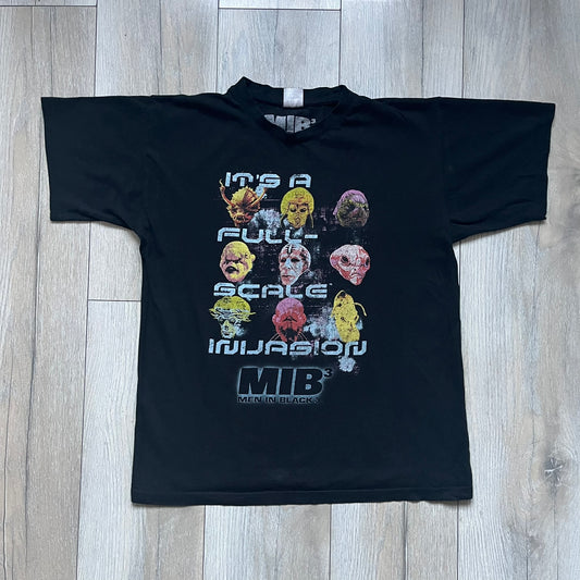 Black Men In Black 3 T-shirt from 2012, featuring a front graphic with nine colorful alien faces arranged in a 3×3 grid. The phrase “It’s a Full Scale Invasion” is printed between the faces, with a white Men In Black 3 logo placed below. Finished with an official MIB neck tag, short sleeves, and a standard crew neckline.