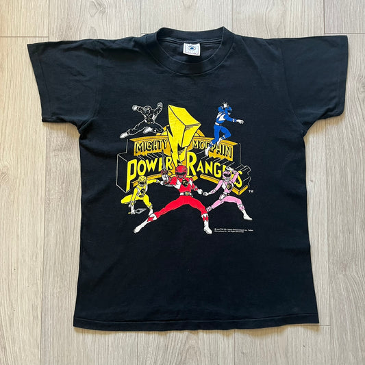 1994 Power Rangers tee with striking full-team graphic, officially licensed by Saban Entertainment. Crafted on a Delta USA-made blank with single stitch finish for authentic vintage feel. Perfect for fans and collectors of classic ‘90s TV.