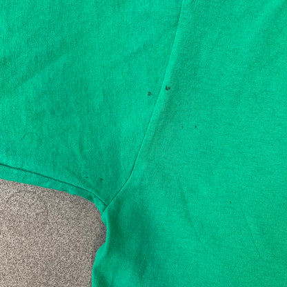 Minecraft 2015 Minecon London Green Tee is a green T-shirt made for Minecon 2015 in London, featuring Big Ben with a Creeper face on the front, with “Minecon London July 4-5” text in Minecraft-style lettering. The upper back displays “Minecon” with “Thanks for Playing” text below, while the sleeves carry a Mojang logo on one side and a Microsoft logo on the other.