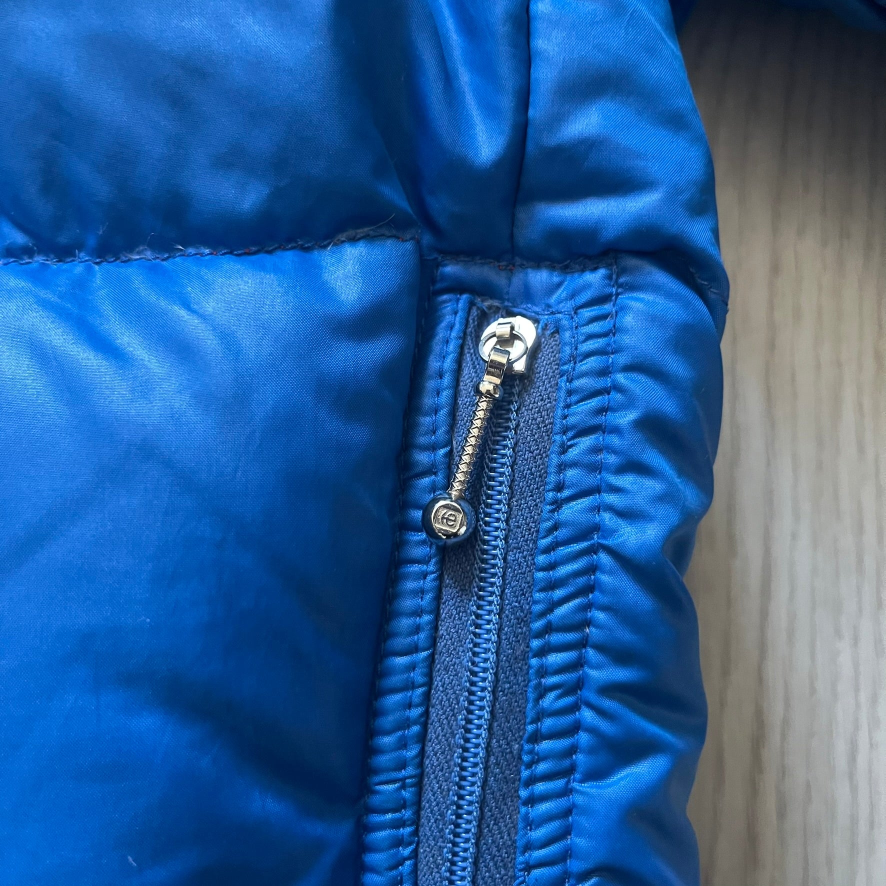 Vintage 1980s Moncler Grenoble down jacket in blue with a contrasting red lining. Features a foldable thin hood hidden in the back, silver-tone buttons and zippers, and the original Moncler patch on the sleeve. A rare French-made piece with authentic Grenoble labels, distinct from the brand’s modern ski line.