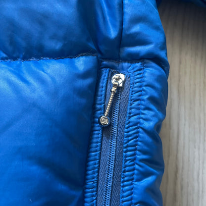 Vintage 1980s Moncler Grenoble down jacket in blue with a contrasting red lining. Features a foldable thin hood hidden in the back, silver-tone buttons and zippers, and the original Moncler patch on the sleeve. A rare French-made piece with authentic Grenoble labels, distinct from the brand’s modern ski line.