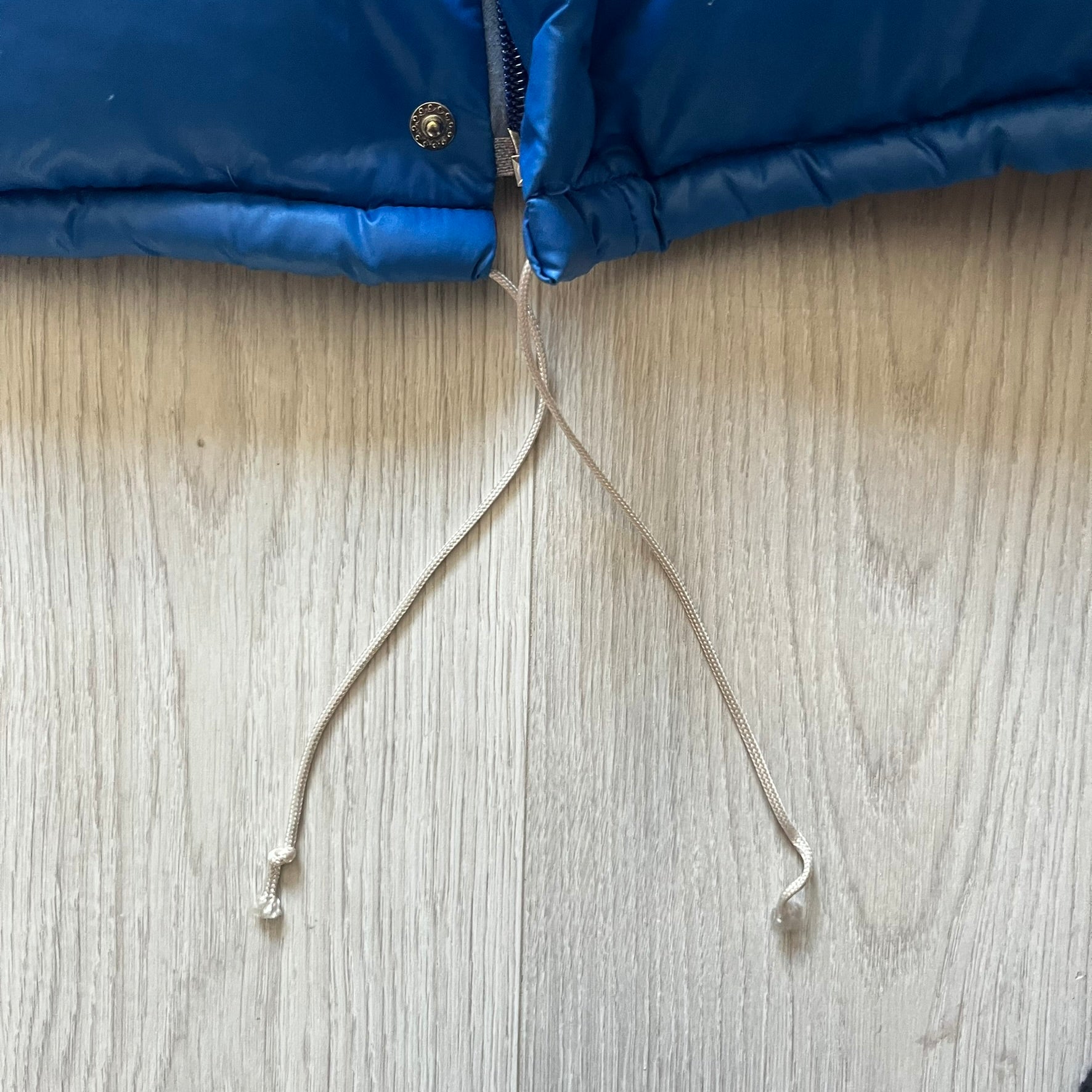 Vintage 1980s Moncler Grenoble down jacket in blue with a contrasting red lining. Features a foldable thin hood hidden in the back, silver-tone buttons and zippers, and the original Moncler patch on the sleeve. A rare French-made piece with authentic Grenoble labels, distinct from the brand’s modern ski line.