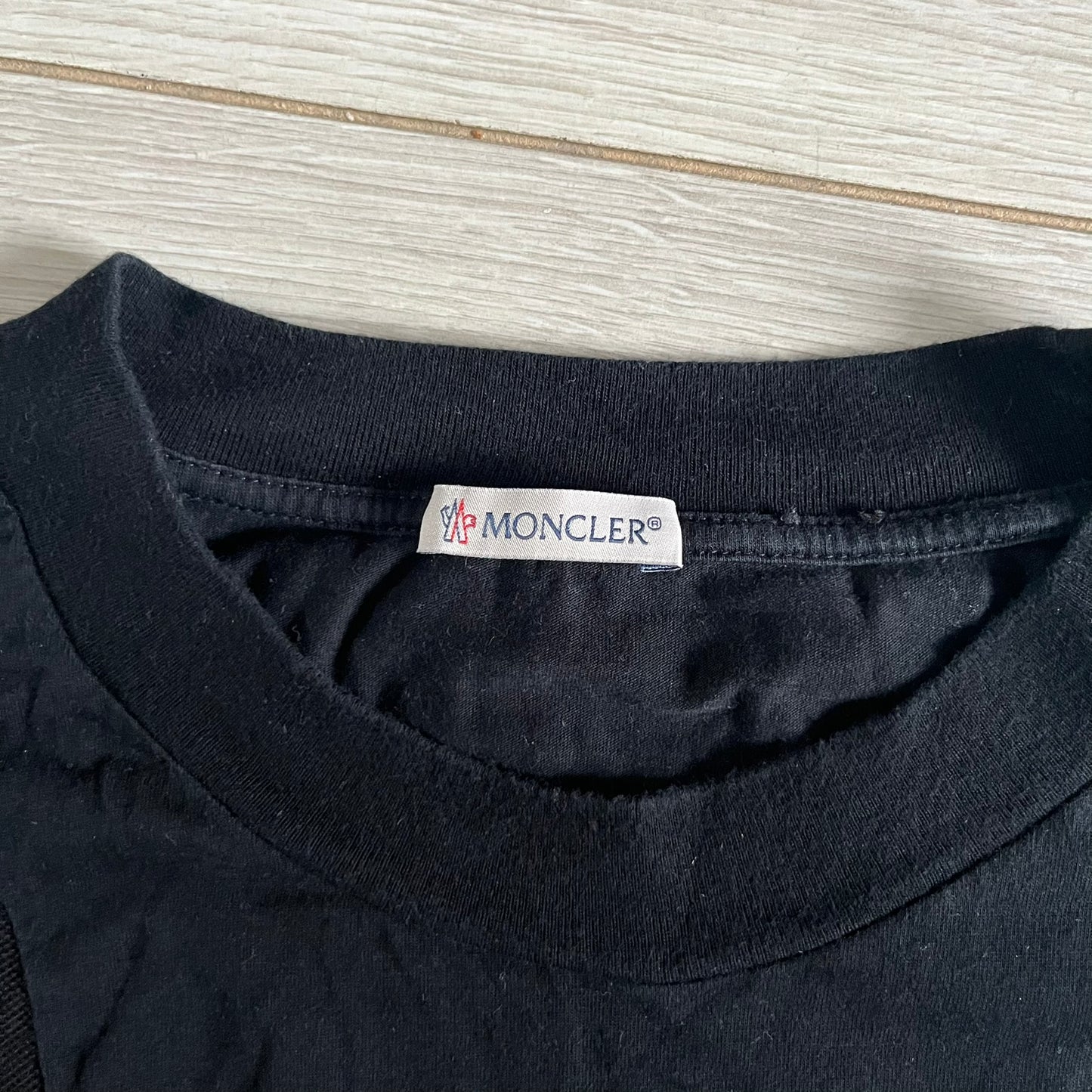 Moncler x Adidas Originals Longsleeve from the FW23 collection. Crafted in cotton jersey, the piece features a three-panel color-block design transitioning from beige to black tones. It includes a silicone chest logo, black Adidas stripes down the sleeves, and a co-branded Moncler x Adidas logo patch on the arm.