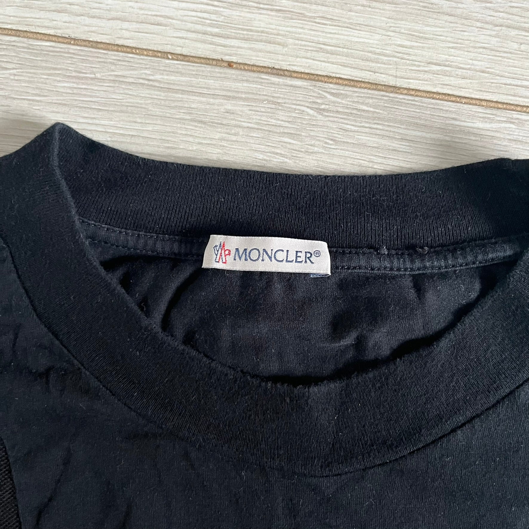 Moncler x Adidas Originals Longsleeve from the FW23 collection. Crafted in cotton jersey, the piece features a three-panel color-block design transitioning from beige to black tones. It includes a silicone chest logo, black Adidas stripes down the sleeves, and a co-branded Moncler x Adidas logo patch on the arm.