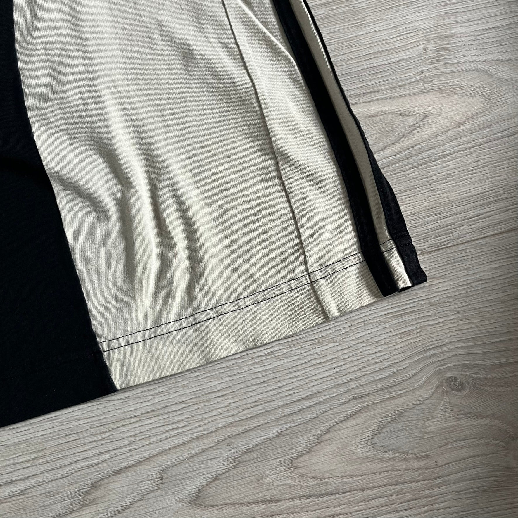 Moncler x Adidas Originals Longsleeve from the FW23 collection. Crafted in cotton jersey, the piece features a three-panel color-block design transitioning from beige to black tones. It includes a silicone chest logo, black Adidas stripes down the sleeves, and a co-branded Moncler x Adidas logo patch on the arm.