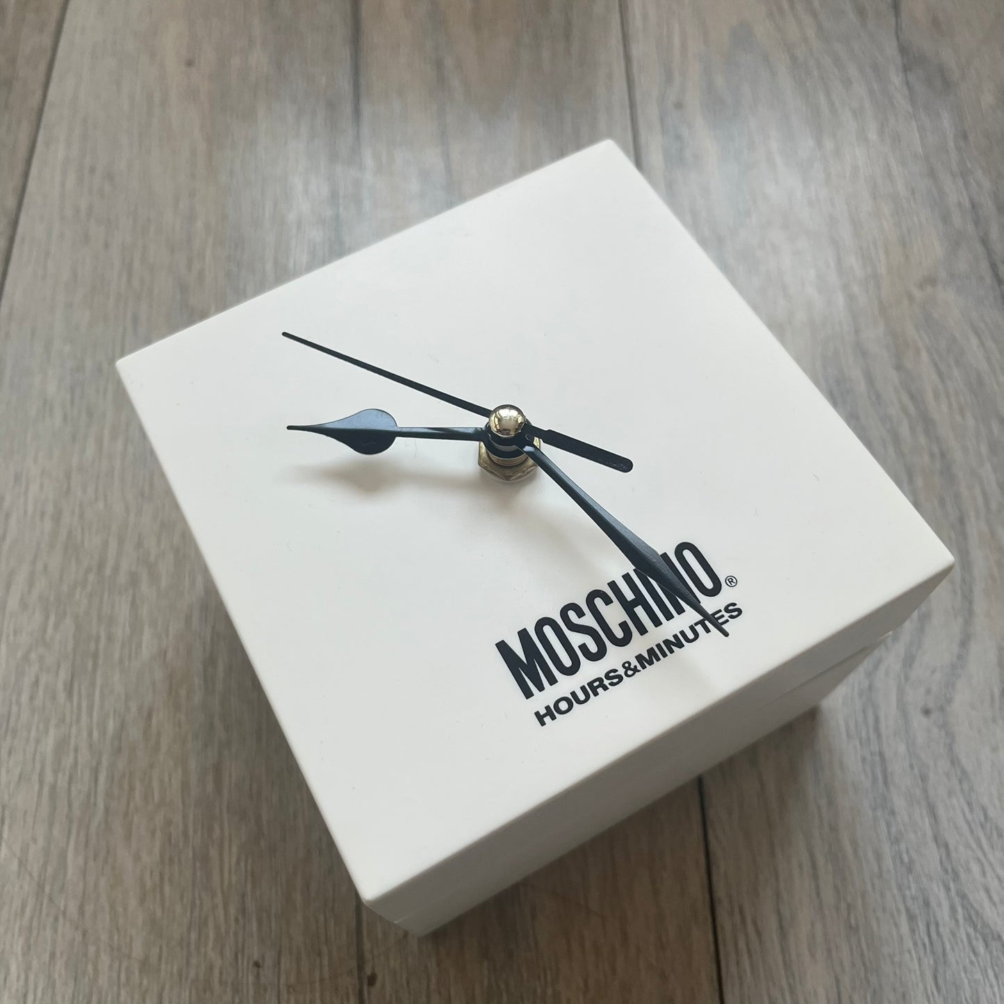Moschino “Don’t Be 2 Late” Clear Blue 5 Dial Analog Watch in a light blue colorway, featuring an extended plastic strap and case construction. The design includes five separate dials with individual movements: four pearlescent faces in varying tones and one fully transparent dial, each with different markers including Roman numerals, Arabic numerals, or crystal hour indices. Silver-tone metal bezel rings and crowns (smooth, ridged, and crystal-set variations) frame the dials, while stainless steel casebacks