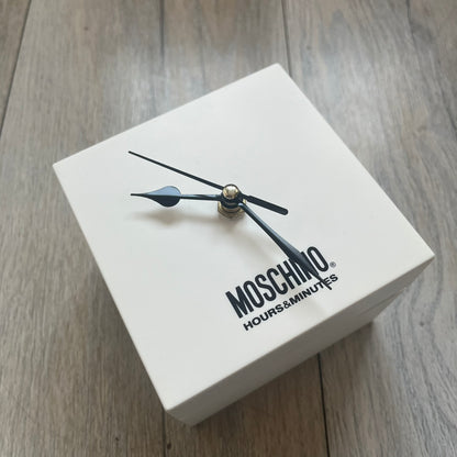 Moschino “Don’t Be 2 Late” Clear Blue 5 Dial Analog Watch in a light blue colorway, featuring an extended plastic strap and case construction. The design includes five separate dials with individual movements: four pearlescent faces in varying tones and one fully transparent dial, each with different markers including Roman numerals, Arabic numerals, or crystal hour indices. Silver-tone metal bezel rings and crowns (smooth, ridged, and crystal-set variations) frame the dials, while stainless steel casebacks