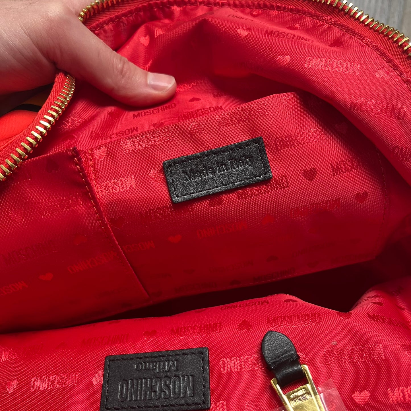 Moschino FW14 McDonald’s Fast Food Backpack is a red nylon backpack from the Autumn/Winter 2014 collection, designed by Jeremy Scott for his debut Moschino lineup. The front features yellow curved arches inspired by McDonald’s branding, with a front zip pocket printed with yellow Moschino text and black “Over 20 Billion Served” slogan. The bag includes gold-tone zippers with black leather pulls, black straps with Moschino logos, a branded interior lining, and comes with a Moschino dust bag. Made in Italy.