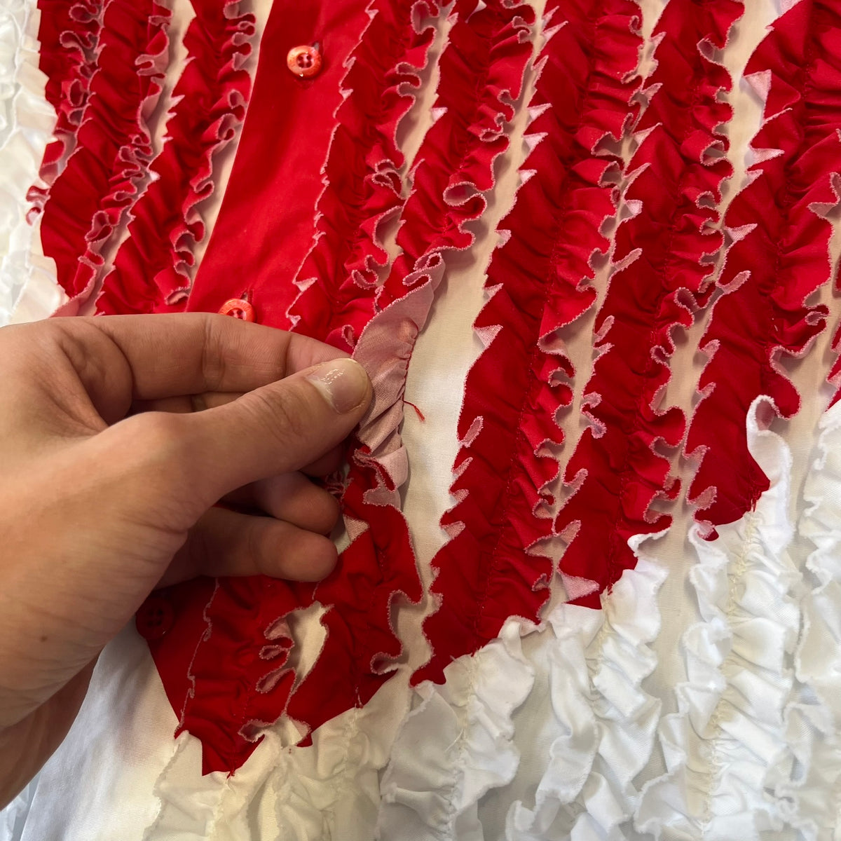 Moschino SS2000 Ruffled Heart Button Up Shirt is a white button-up made in Italy, featuring a ruffled rectangular panel on the front with an asymmetrically placed red heart at its center. It has Moschino-branded buttons, and a black Moschino text logo sits on the back just below the collar.