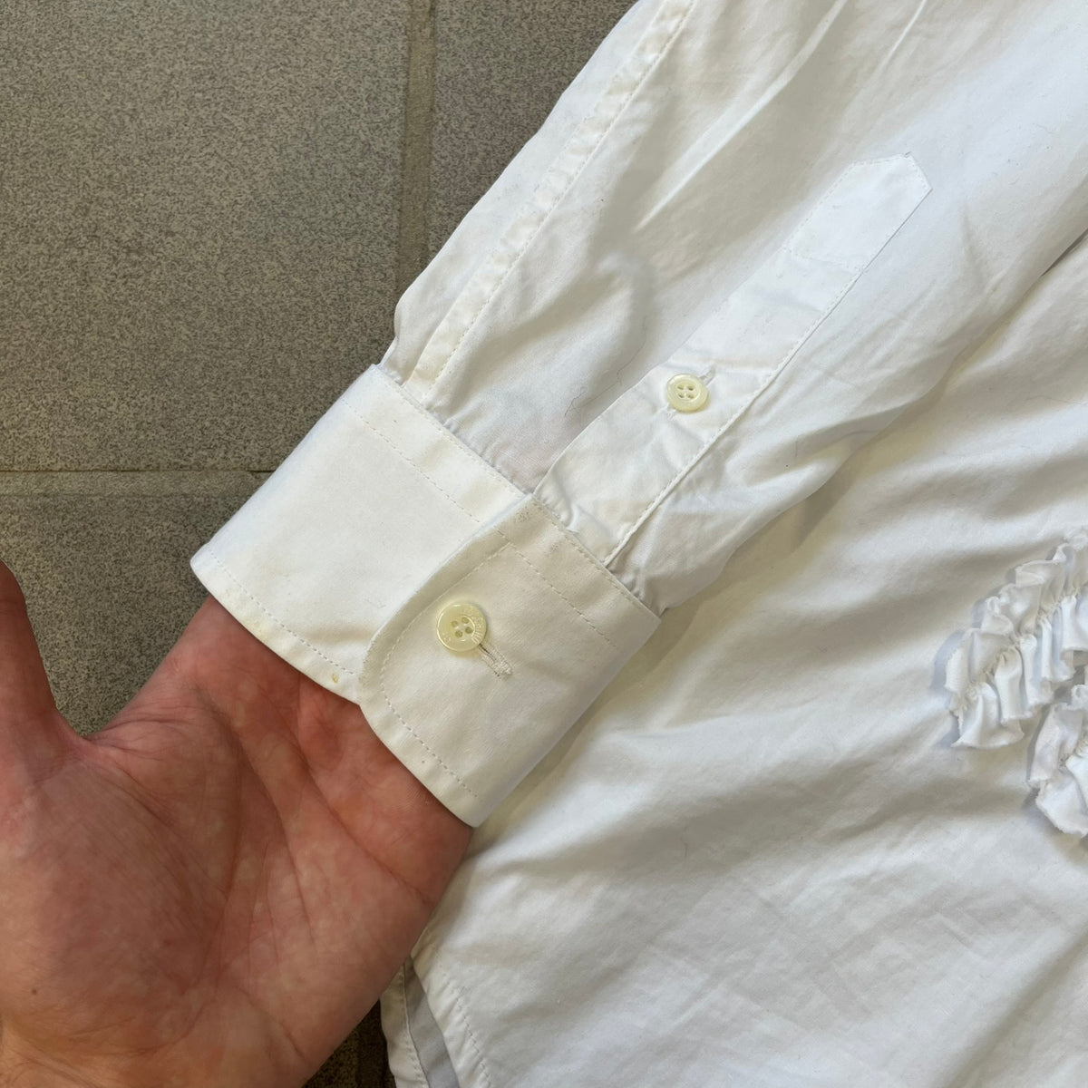Moschino SS2000 Ruffled Heart Button Up Shirt is a white button-up made in Italy, featuring a ruffled rectangular panel on the front with an asymmetrically placed red heart at its center. It has Moschino-branded buttons, and a black Moschino text logo sits on the back just below the collar.