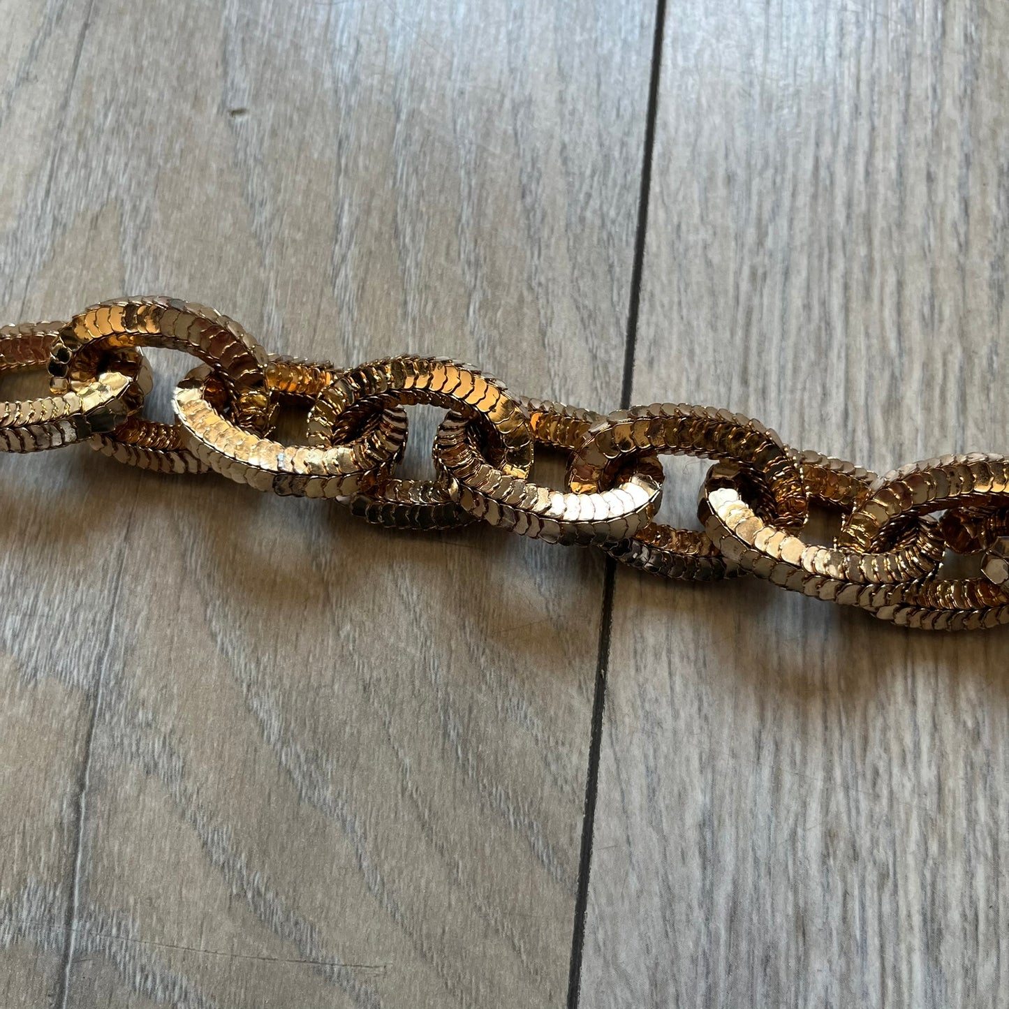 Moschino x H&M 2018 Gold Bracelet is a chunky chain bracelet released as part of the Moschino x H&M collaboration designed by Jeremy Scott. The bracelet features oversized O-shaped links in a gold-tone finish and a T-bar clasp closure. Produced for the 2018 capsule collection and made in Vietnam, it comes with the original white H&MOSCHINO box.