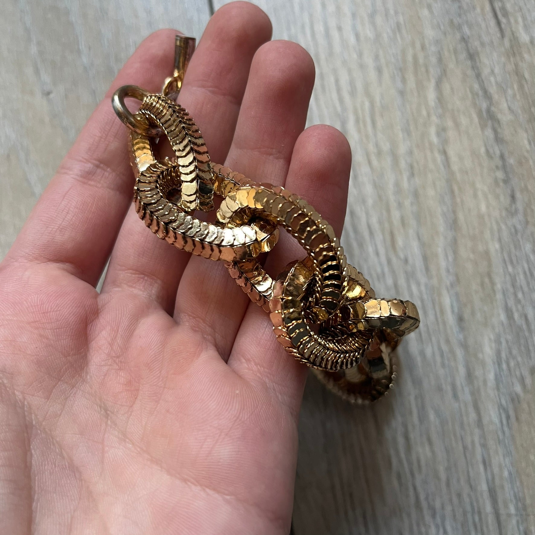 Moschino x H&M 2018 Gold Bracelet is a chunky chain bracelet released as part of the Moschino x H&M collaboration designed by Jeremy Scott. The bracelet features oversized O-shaped links in a gold-tone finish and a T-bar clasp closure. Produced for the 2018 capsule collection and made in Vietnam, it comes with the original white H&MOSCHINO box.