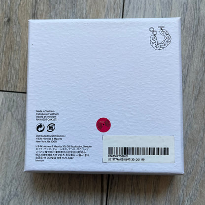 Moschino x H&M 2018 Gold Bracelet is a chunky chain bracelet released as part of the Moschino x H&M collaboration designed by Jeremy Scott. The bracelet features oversized O-shaped links in a gold-tone finish and a T-bar clasp closure. Produced for the 2018 capsule collection and made in Vietnam, it comes with the original white H&MOSCHINO box.