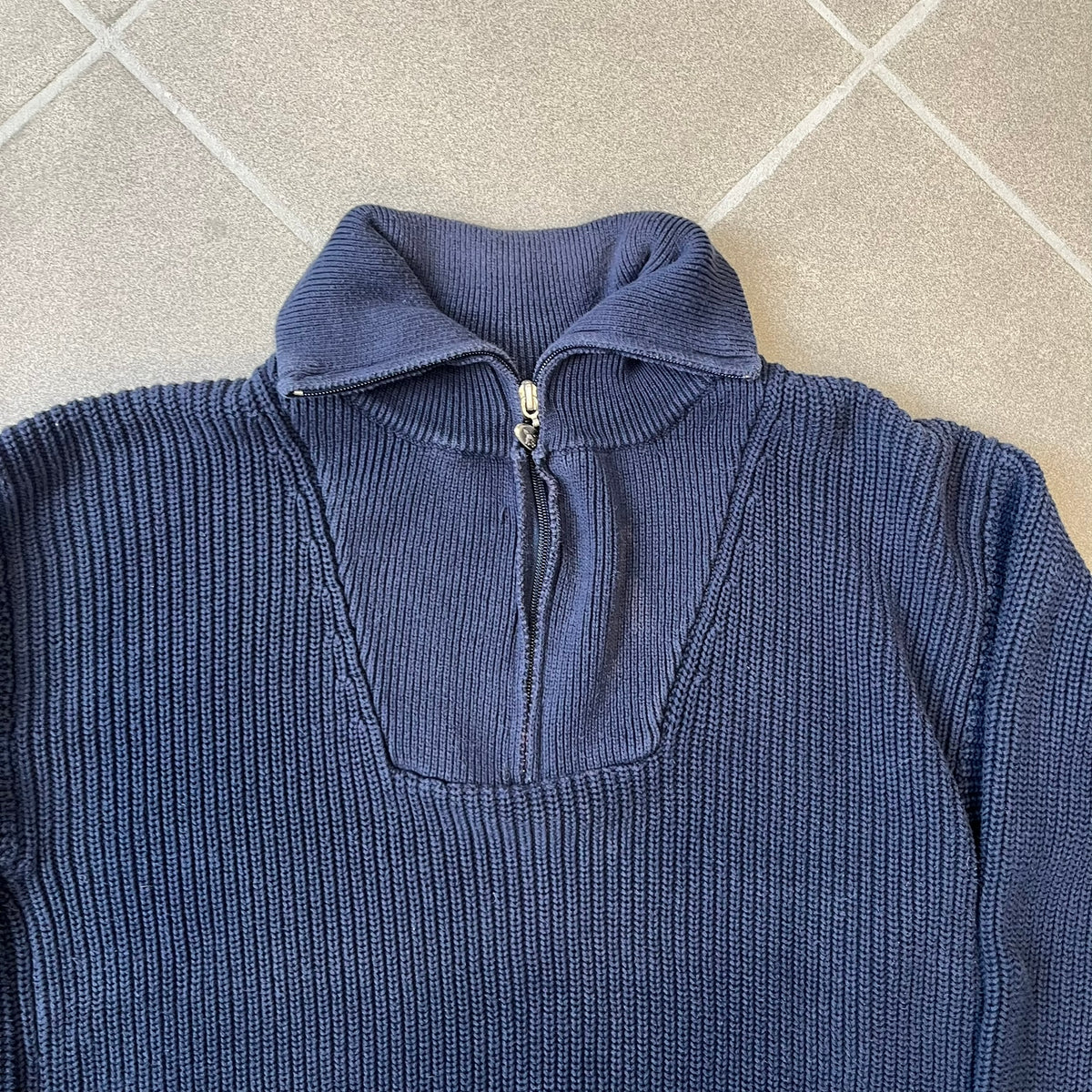 Mustang Jeans Navy Troyer Sweater is a heavyweight, high-quality navy troyer sweater featuring a Mustang Jeans patch tag on the lower front and a silver-colored horse zipper pull. The design includes a collar typical of the troyer style.