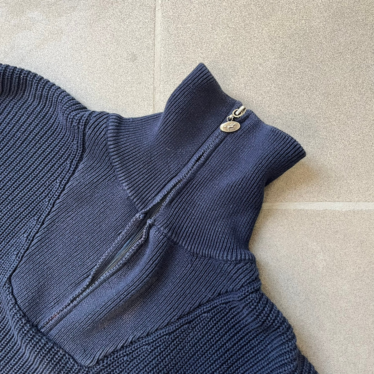 Mustang Jeans Navy Troyer Sweater is a heavyweight, high-quality navy troyer sweater featuring a Mustang Jeans patch tag on the lower front and a silver-colored horse zipper pull. The design includes a collar typical of the troyer style.