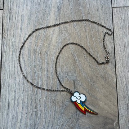 My Little Pony Rainbow Dash 2010s Necklace produced by WeLoveFine. Constructed from stainless steel, it features a slightly raised steel outline pendant of the Rainbow Dash cloud and three-color lightning bolt logo, finished with enamel detailing. The pendant is attached to a thin stainless steel chain.