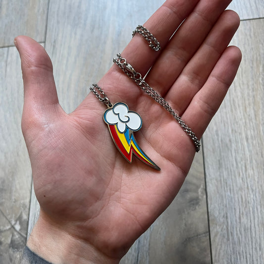 My Little Pony Rainbow Dash 2010s Necklace produced by WeLoveFine. Constructed from stainless steel, it features a slightly raised steel outline pendant of the Rainbow Dash cloud and three-color lightning bolt logo, finished with enamel detailing. The pendant is attached to a thin stainless steel chain.
