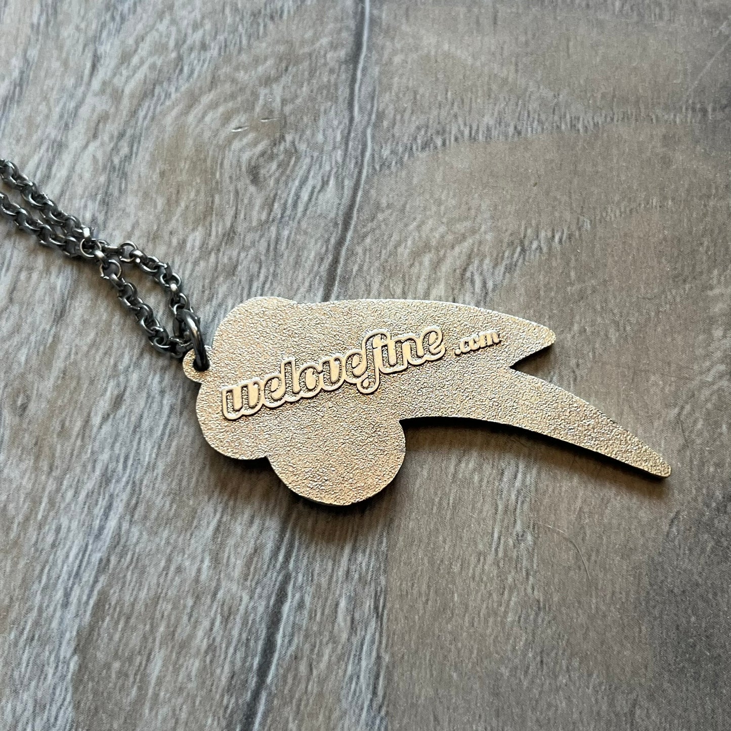 My Little Pony Rainbow Dash 2010s Necklace produced by WeLoveFine. Constructed from stainless steel, it features a slightly raised steel outline pendant of the Rainbow Dash cloud and three-color lightning bolt logo, finished with enamel detailing. The pendant is attached to a thin stainless steel chain.