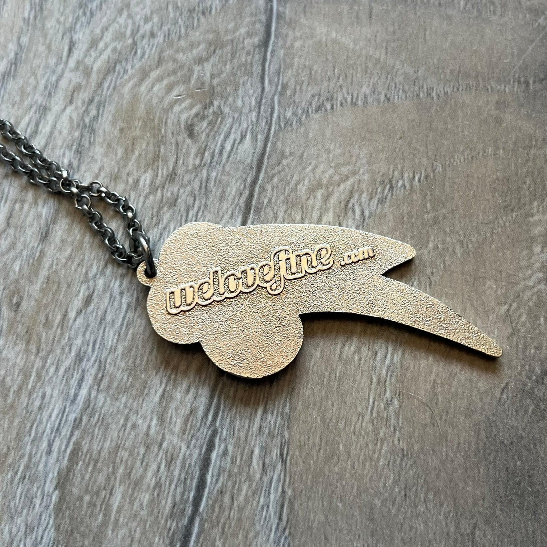 My Little Pony Rainbow Dash 2010s Necklace produced by WeLoveFine. Constructed from stainless steel, it features a slightly raised steel outline pendant of the Rainbow Dash cloud and three-color lightning bolt logo, finished with enamel detailing. The pendant is attached to a thin stainless steel chain.
