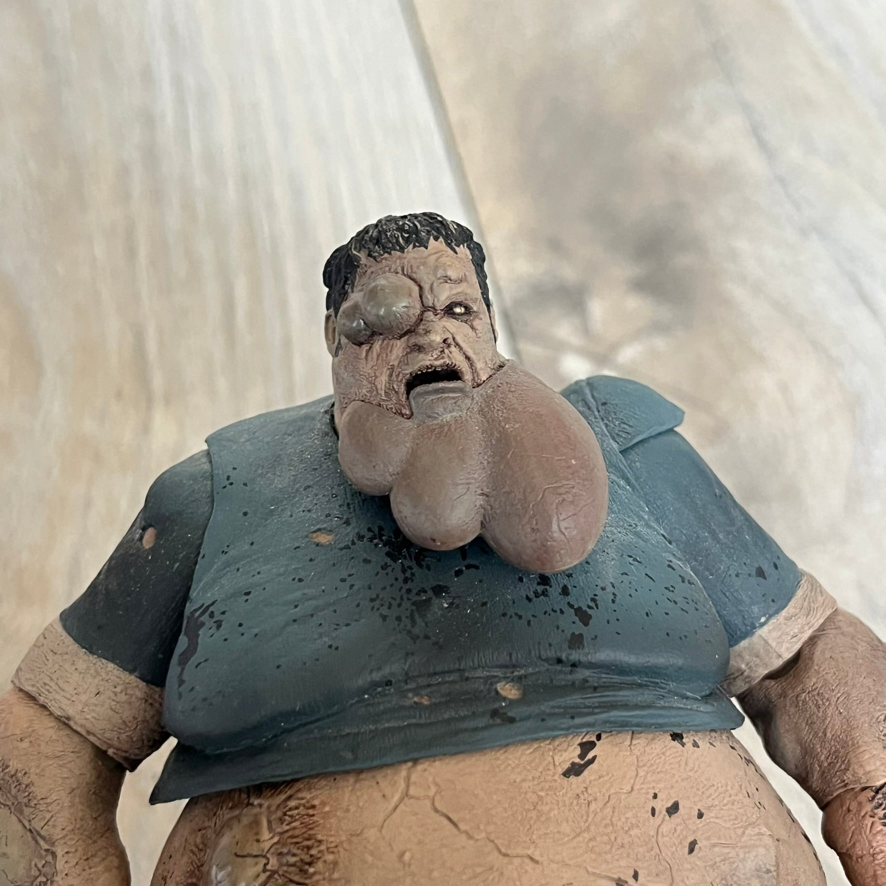 NECA Left 4 Dead Boomer Action Figure is a plastic figure released in September 2012, based on the Boomer character from the Left 4 Dead game. The figure features detailed sculpting with articulated arms and legs for adjustable posing. NECA and Valve markings are present on the underside of the feet.