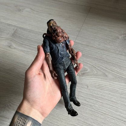 NECA Left 4 Dead Smoker Action Figure released in September 2012, based on the iconic zombie from Valve’s hit game L4D. Standing at 7-inch (1/12 scale), this plastic figure features detailed sculpting, articulation, and originally included a bendable tongue for dynamic posing (missing in this piece).