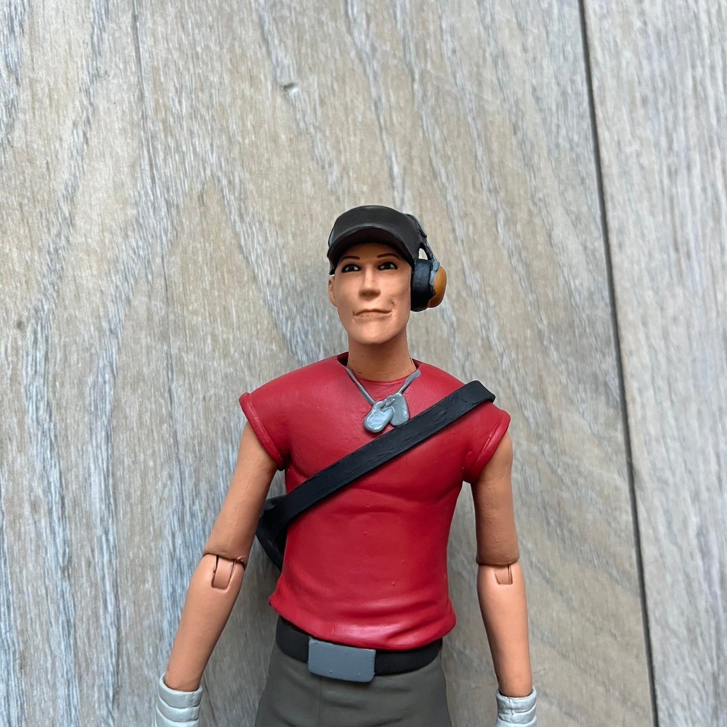 NECA Team Fortress 2 RED Scout Series 4 action figure from 2018. The figure measures approximately 7 inches in scale and recreates the Scout character from Valve’s Team Fortress 2 with game-accurate styling. It features more than 25 points of articulation and comes with three weapons: a scattergun, pistol, and bat.