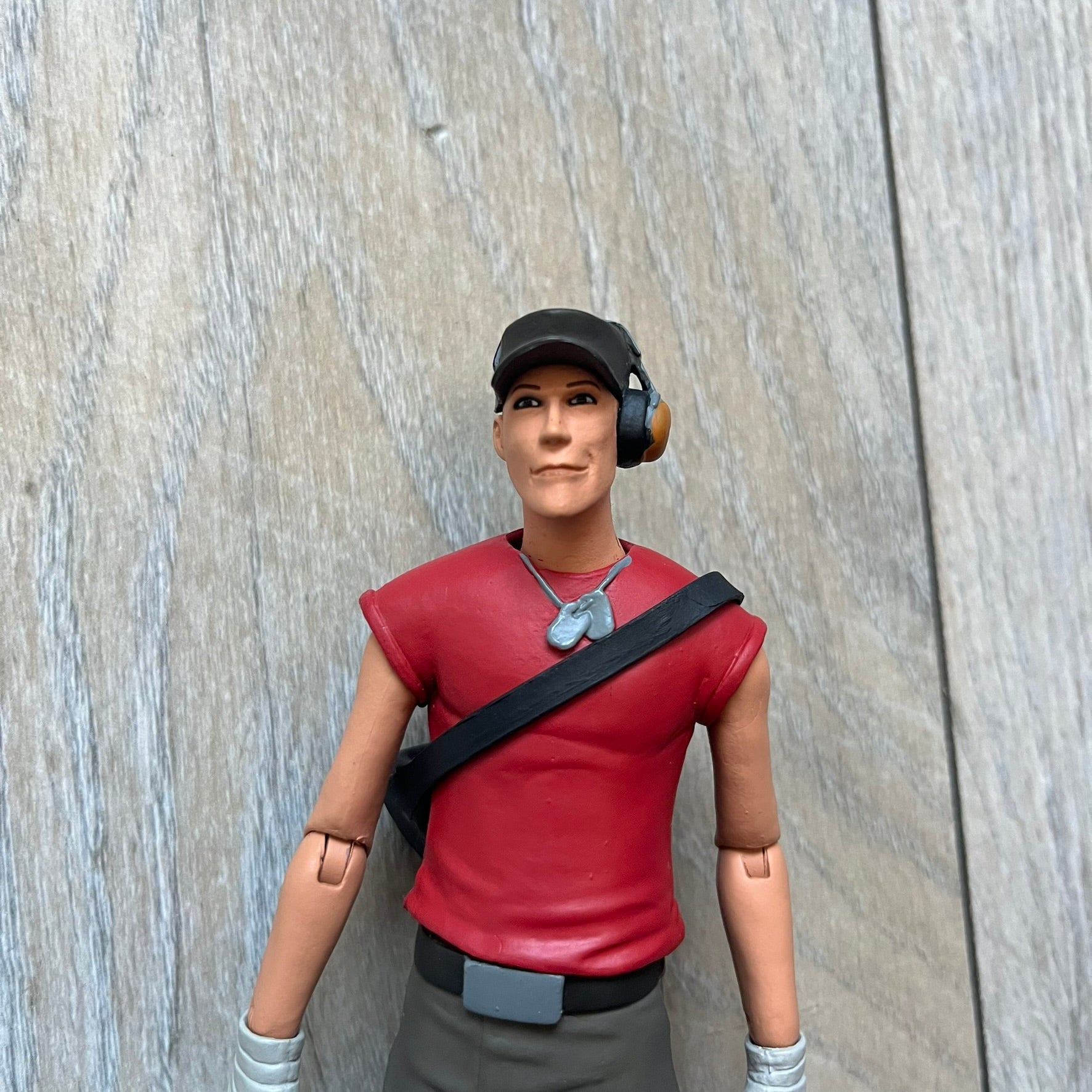 NECA Team Fortress 2 RED Scout Series 4 action figure from 2018. The figure measures approximately 7 inches in scale and recreates the Scout character from Valve’s Team Fortress 2 with game-accurate styling. It features more than 25 points of articulation and comes with three weapons: a scattergun, pistol, and bat.